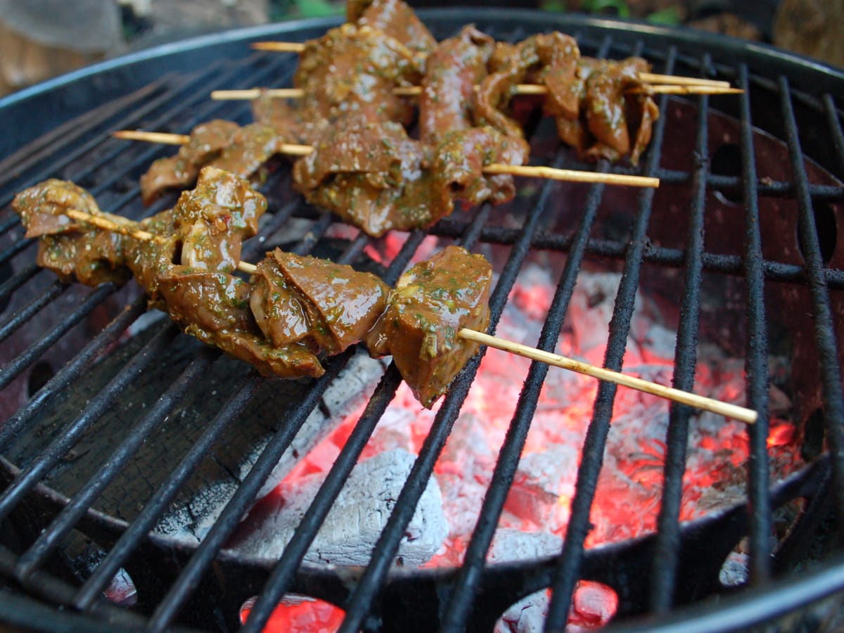 Anticuchos de corazón en brochetas sobre la parrilla