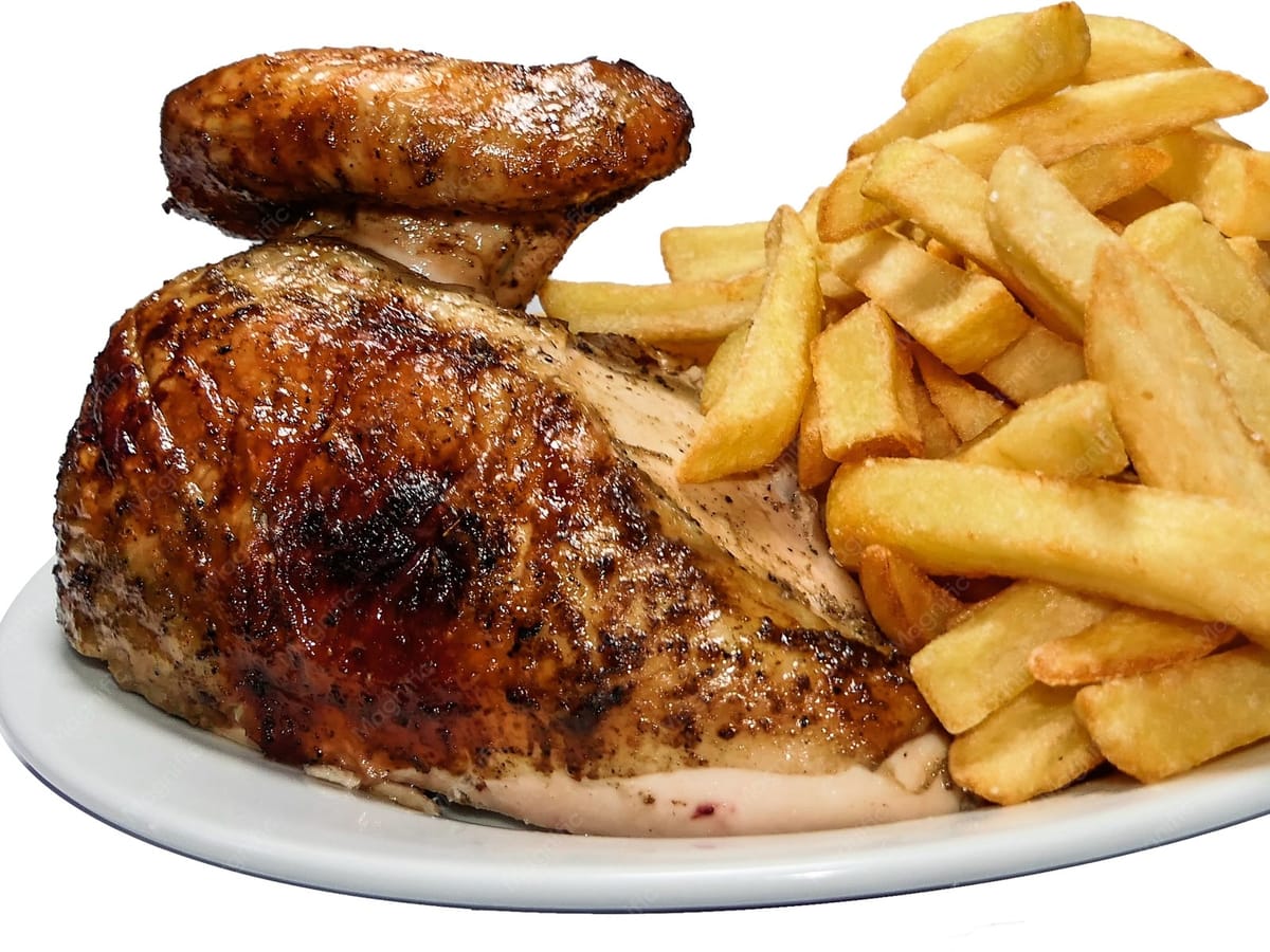 Medio pollo a la brasa servido en plato con papas fritas